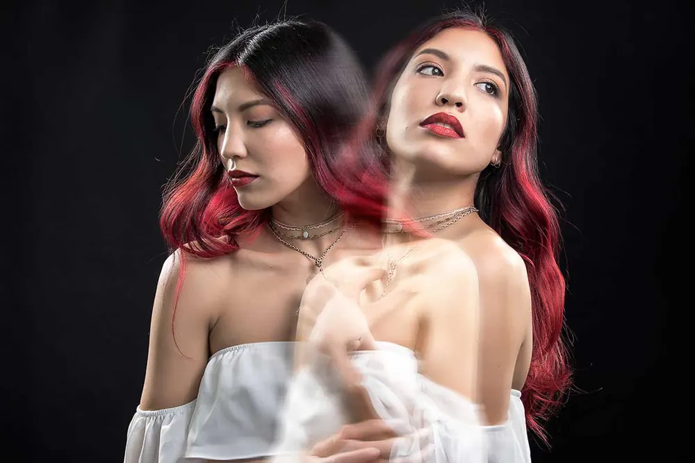 Doppia esposizione di una donna coi capelli rossi, due volti sovrapposti in controluce